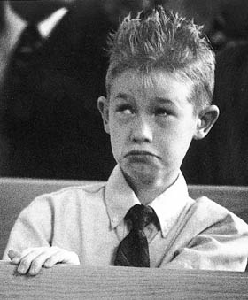 Bored kid with spiked hair at wedding.